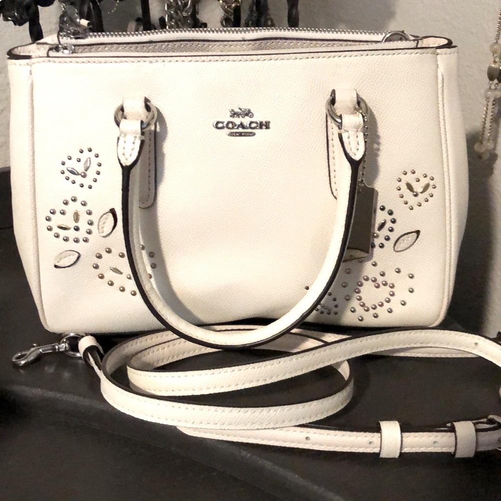 White coach purse with heart shape studs.